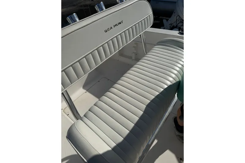 Slide: The Image of 2005 Sea Hunt Triton 220 boat seat with white upholstery and chrome accents. - 10