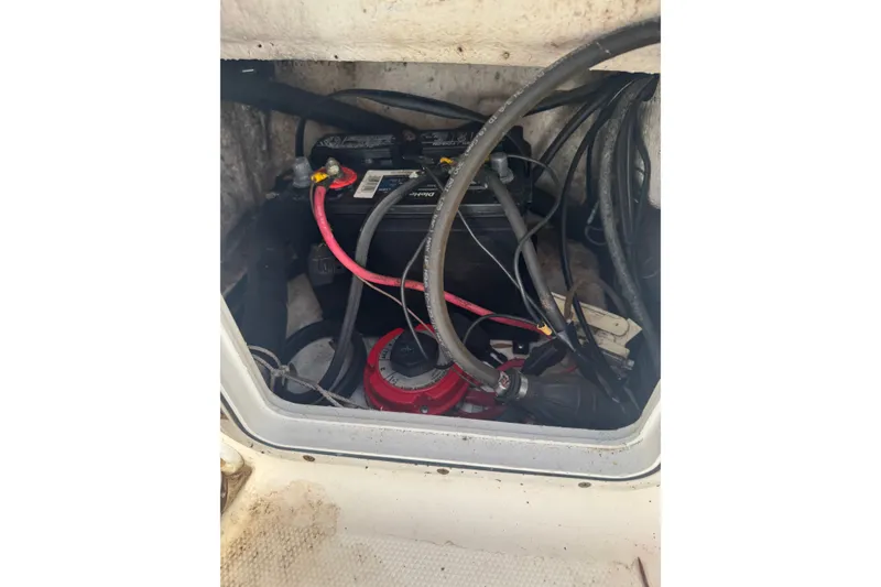 Slide: The Image of Battery compartment of a 2005 Sea Hunt Triton 220 boat with cables and connections. - 9