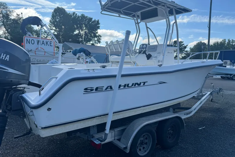 The Image of 2005 Sea Hunt Triton 220 boat on trailer, featuring Yamaha outboard motor. - 0