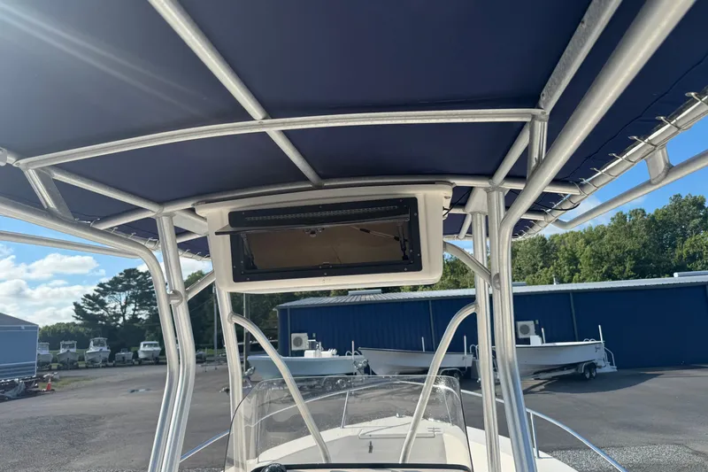 Slide: The Image of 2005 Sea Hunt Triton 220 boat with T-top and electronics box, parked outdoors. - 20