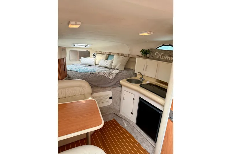 Slide: The Image of Interior of a 1999 Monterey 296 Cruiser with cozy bed, kitchenette, and dining area. - 6