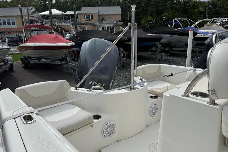 Slide: The Image of 2006 Boston Whaler 210 Outrage boat interior with seating and motor, displayed at a marina. - 7