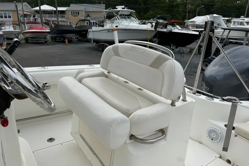 Slide: The Image of 2006 Boston Whaler 210 Outrage boat interior with white seating and steering wheel. - 6