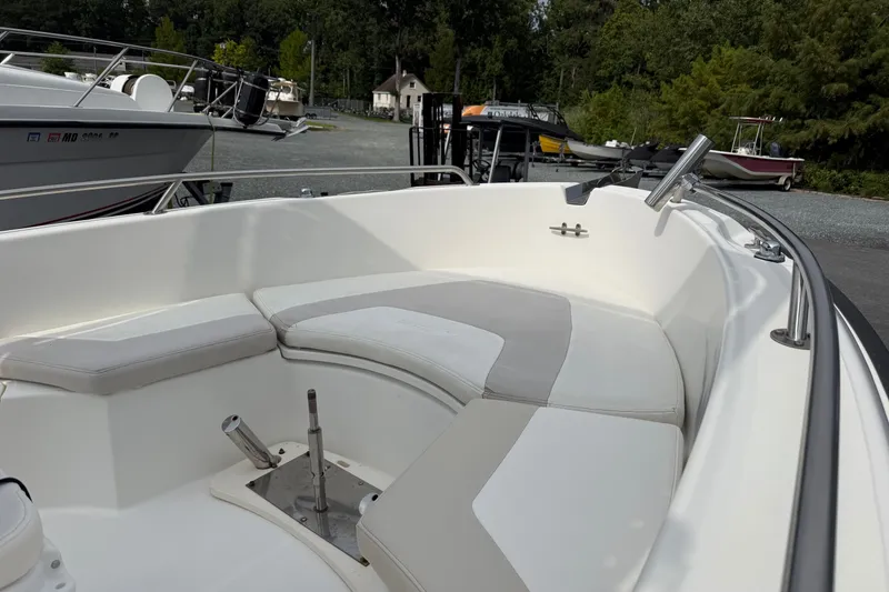 Slide: The Image of 2006 Boston Whaler 210 Outrage boat interior with cushioned seating and stainless steel fittings. - 8