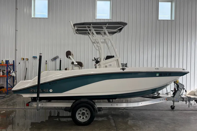 The Image of 2021 Yamaha Boats 195 FSH Sport in a garage on a trailer. - 1
