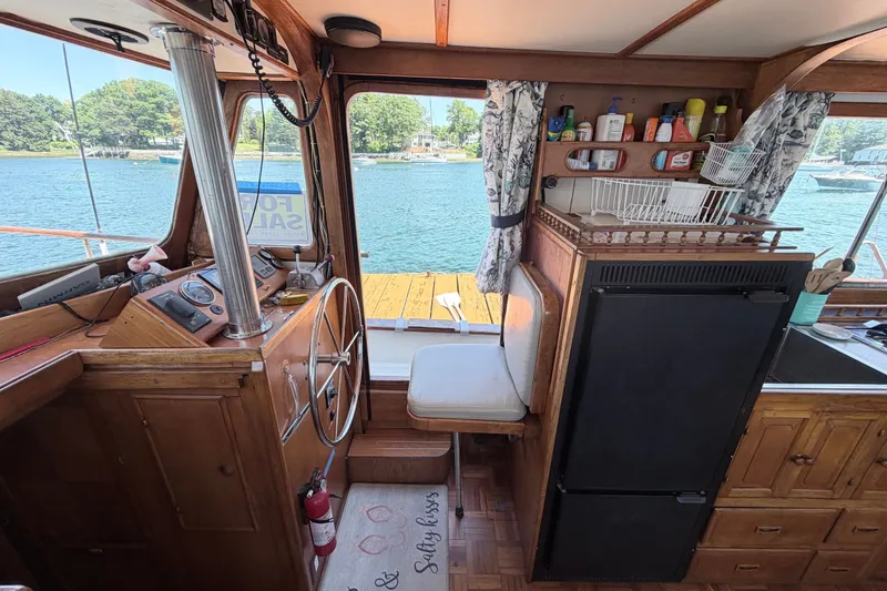 Slide: The Image of Interior of 1979 Marine Trader 36 boat with helm, fridge, and scenic water view. - 43