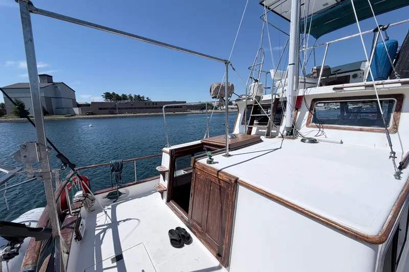 Slide: The Image of 1979 Marine Trader 36 yacht docked by waterfront, clear sky, and industrial buildings in background. - 33