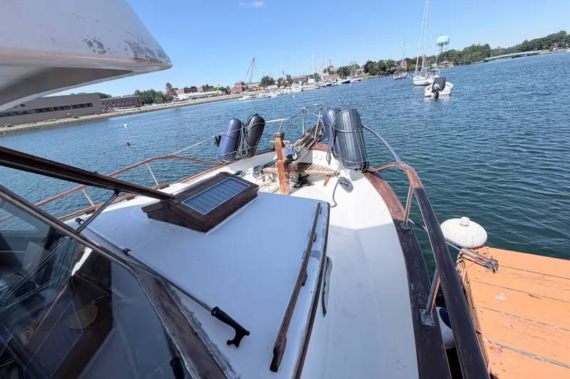 Slide: The Image of 1979 Marine Trader 36 yacht docked in a scenic marina with clear blue water. - 27