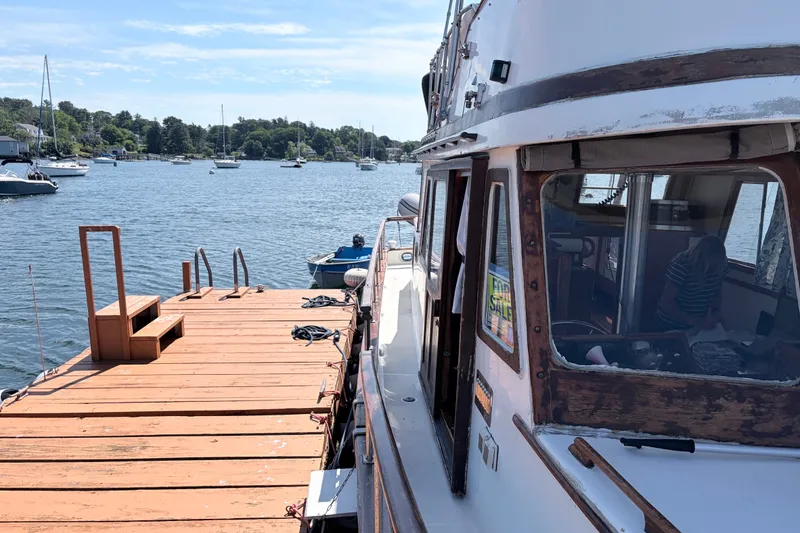 Slide: The Image of 1979 Marine Trader 36 docked by a wooden pier on a sunny day. - 30