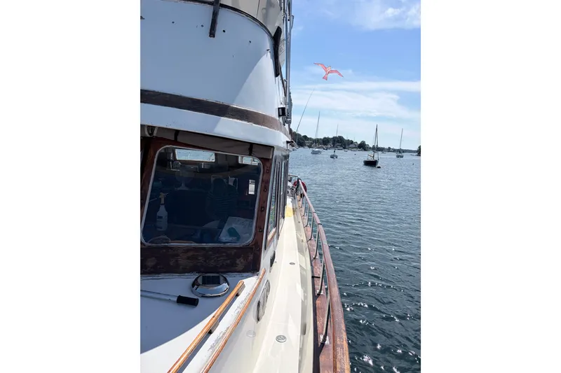 Slide: The Image of 1979 Marine Trader 36 yacht on calm water with sailboats in the background. - 29