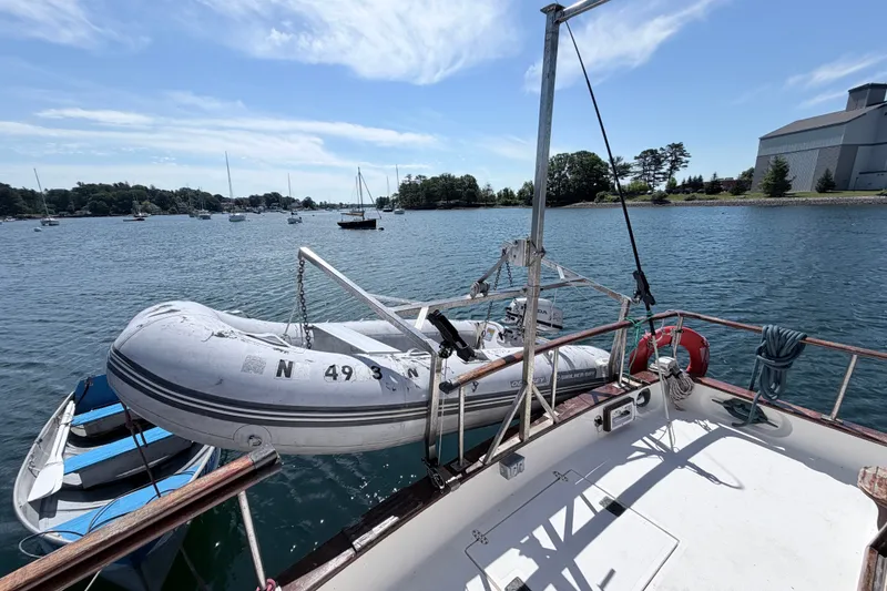 Slide: The Image of 1979 Marine Trader 36 yacht with dinghy on calm waters, surrounded by sailboats. - 37
