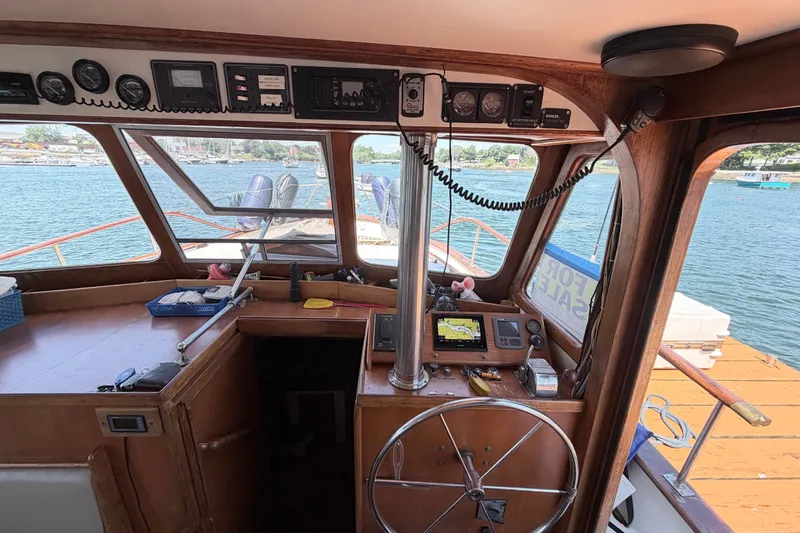 Slide: The Image of Interior view of 1979 Marine Trader 36 boat cockpit with steering wheel and navigation equipment. - 44