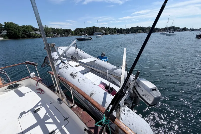 Slide: The Image of 1979 Marine Trader 36 yacht with dinghy on deck, moored in a scenic harbor. - 35