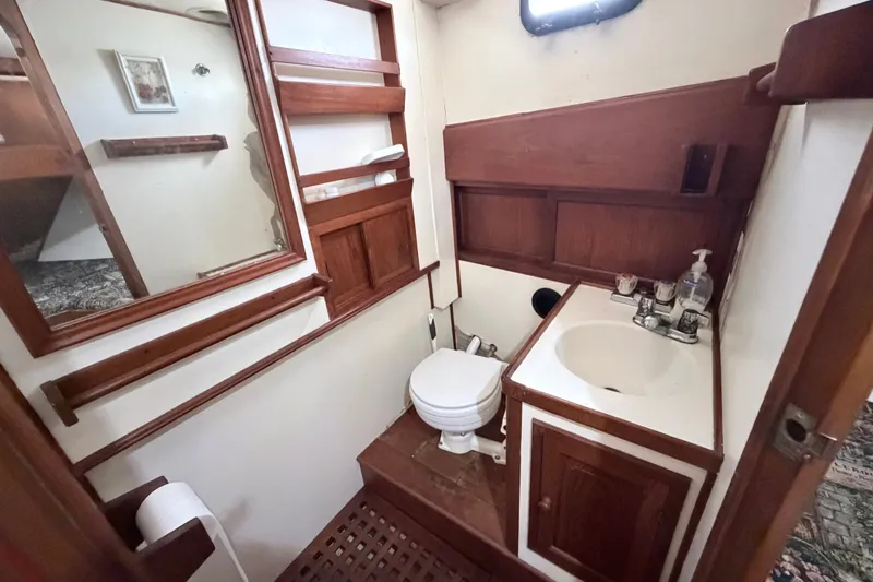 Slide: The Image of 1979 Marine Trader 36 bathroom with wooden accents and compact design. - 24