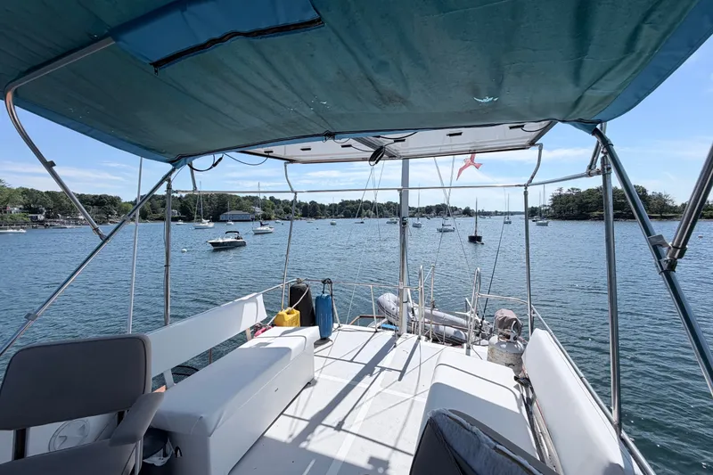 Slide: The Image of 1979 Marine Trader 36 yacht interior with canopy, overlooking a serene harbor with boats. - 40