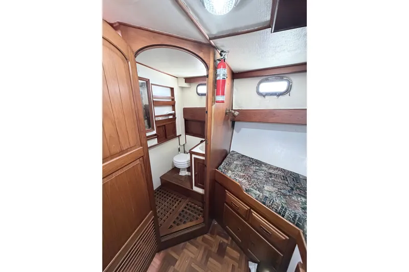 Slide: The Image of 1979 Marine Trader 36 interior with wooden cabinetry, bed, and compact bathroom. - 23