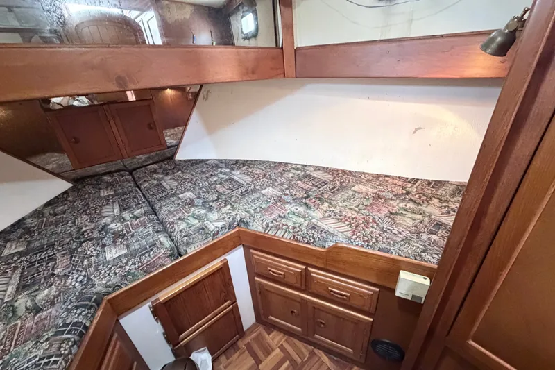 Slide: The Image of Cozy cabin interior of 1979 Marine Trader 36 with patterned bedding and wooden cabinetry. - 22