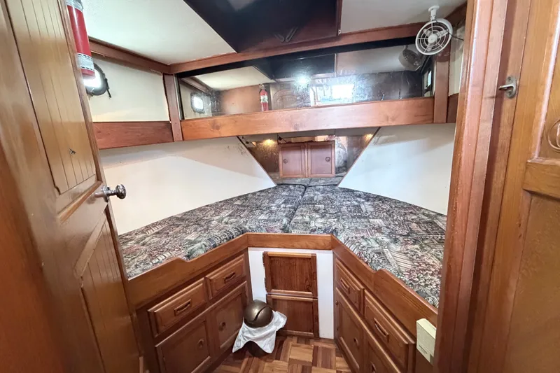 Slide: The Image of Cozy cabin interior of 1979 Marine Trader 36 with wood finish and patterned bedding. - 19