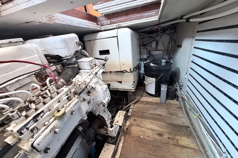 Slide: The Image of Engine room of a 1979 Marine Trader 36 boat, showcasing mechanical components and wiring. - 52