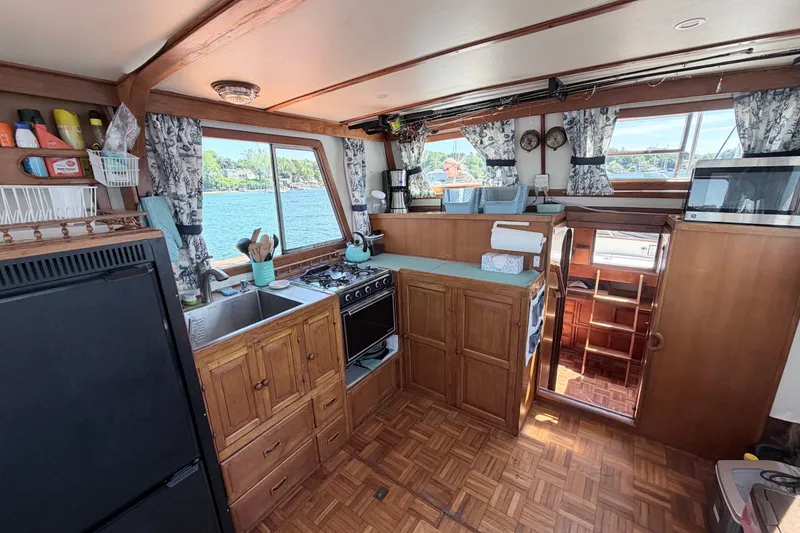 Slide: The Image of 1979 Marine Trader 36 yacht kitchen with wood cabinetry, stove, and scenic window view. - 47
