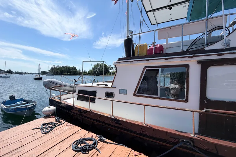 Slide: The Image of 1979 Marine Trader 36 docked at a marina, with clear skies and calm waters. - 32
