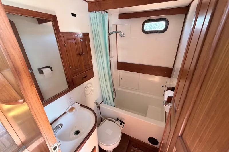 Slide: The Image of Bathroom interior of a 1979 Marine Trader 36 yacht with wood accents and compact design. - 16