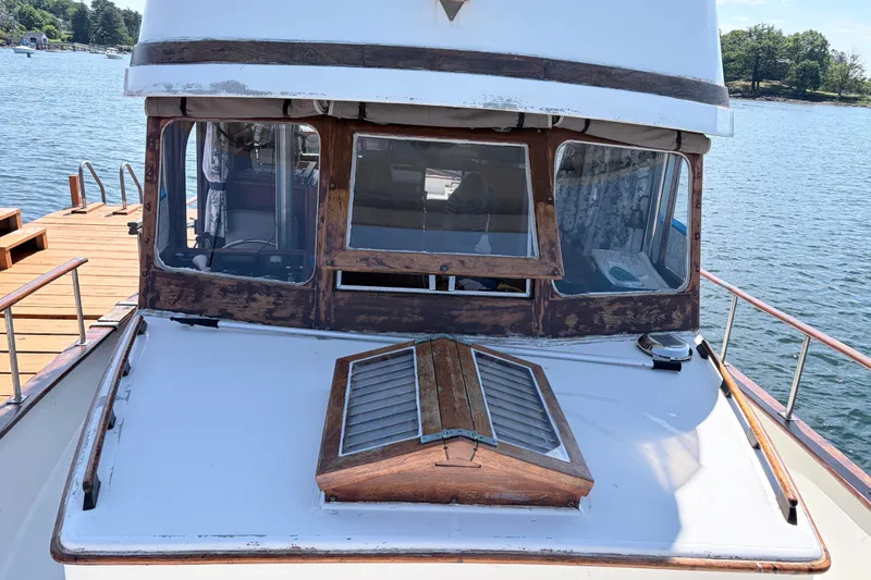 Slide: The Image of 1979 Marine Trader 36 boat docked by a wooden pier on a sunny day. - 25