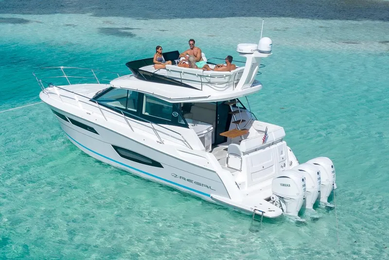 Slide: The Image of Manufacturer Provided Image: 2026 Regal 38 FXO yacht cruising in clear turquoise waters with passengers relaxing on deck. - 6