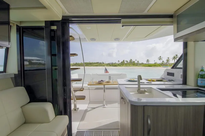 Slide: The Image of Manufacturer Provided Image: Interior view of 2026 Regal 38 FXO yacht with kitchen and ocean backdrop. - 16