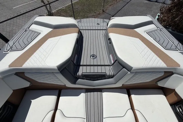 Slide: The Image of 2022 Nautique Super Air Nautique G25 boat interior with cushioned seating and sleek design. - 14
