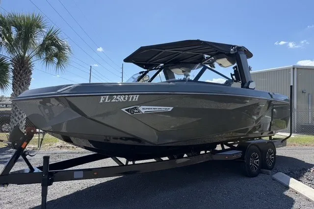 The Image of 2022 Nautique Super Air Nautique G25 boat on trailer, parked outdoors under clear sky. - 1