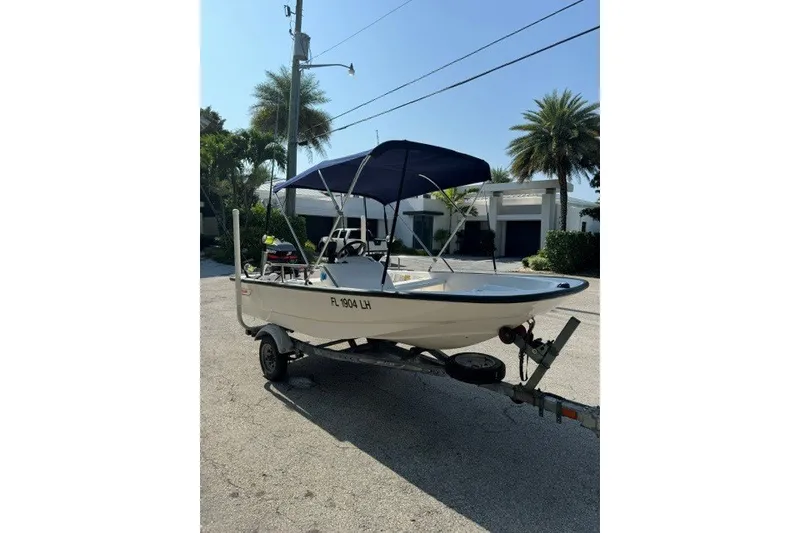 Slide: The Image of 2000 Boston Whaler Sport 13 boat on trailer with canopy, parked outdoors. - 8