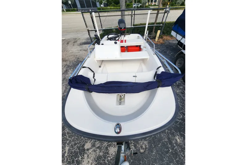 Slide: The Image of 2000 Boston Whaler Sport 13 boat, white hull, parked on a trailer, outdoor setting. - 6