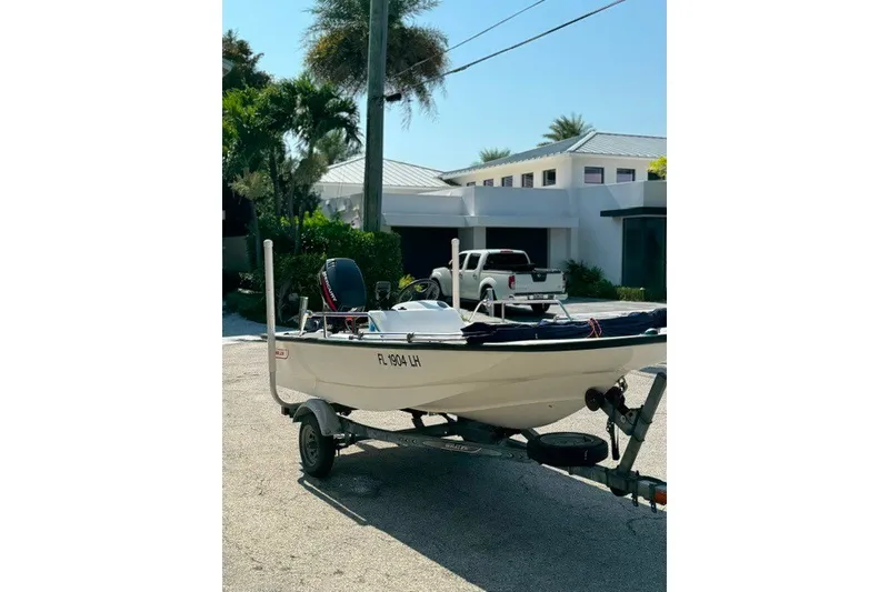 Slide: The Image of 2000 Boston Whaler Sport 13 boat on trailer, parked in residential driveway. - 14
