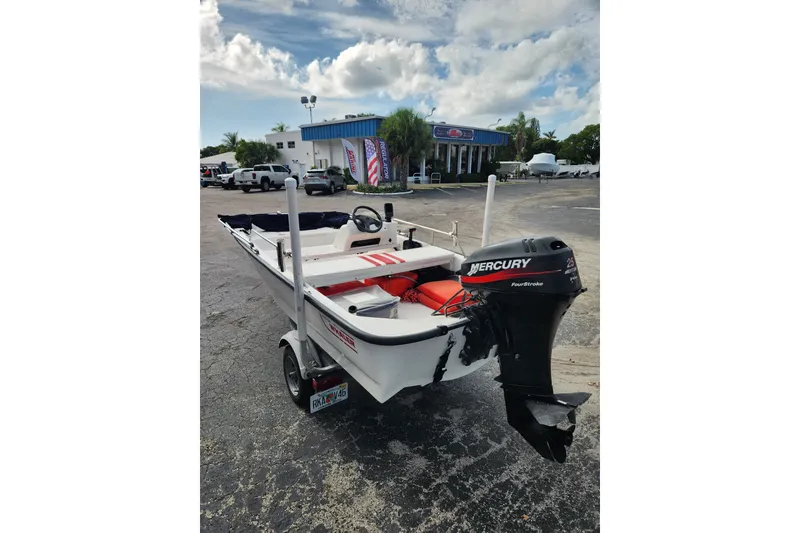 Slide: The Image of 2000 Boston Whaler Sport 13 boat with Mercury engine on a trailer in a parking lot. - 3