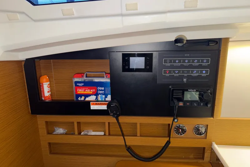 Slide: The Image of Control panel of 2022 Jeanneau Sun Odyssey 410 with first aid kit and radio equipment. - 32