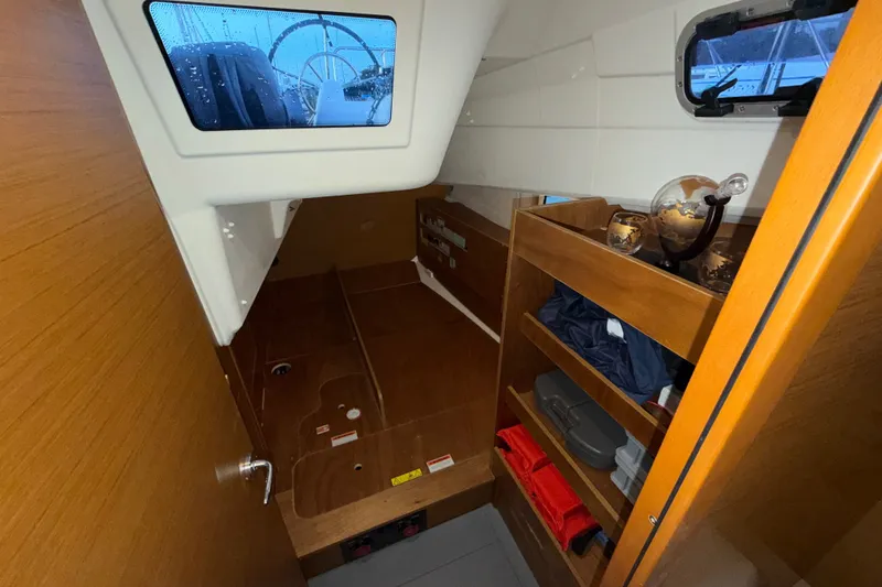 Slide: The Image of Interior cabin of 2022 Jeanneau Sun Odyssey 410 sailboat with wooden shelves and window. - 30