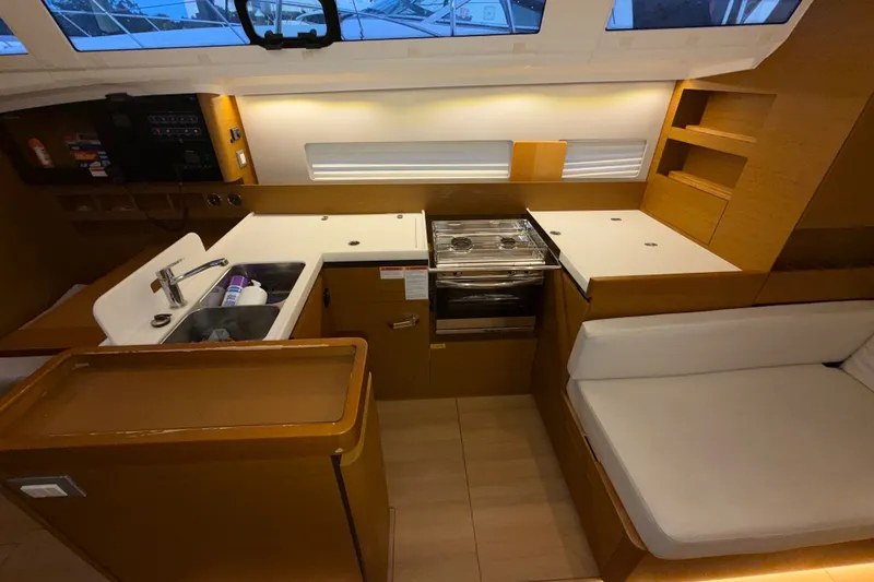 Slide: The Image of Interior of 2022 Jeanneau Sun Odyssey 410 yacht, featuring modern kitchen and seating area. - 35