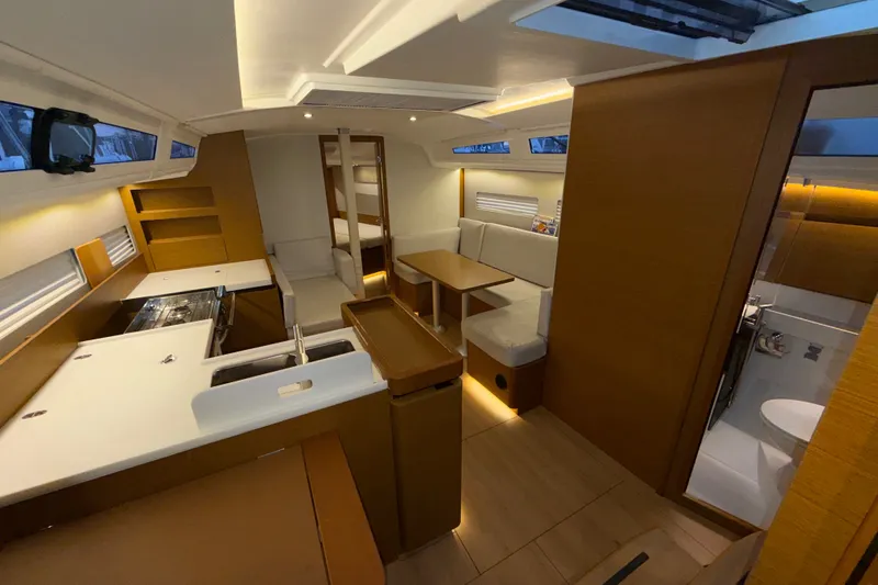 Slide: The Image of Interior of 2022 Jeanneau Sun Odyssey 410 yacht, featuring modern kitchen and cozy seating area. - 34