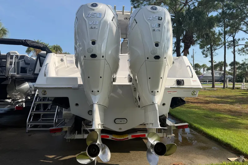 Slide: The Image of 2021 Everglades 335 Center Console with twin 450 V8 engines, parked outdoors. - 2