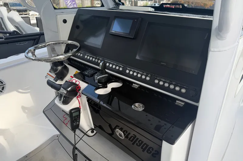 Slide: The Image of 2021 Everglades 335 Center Console boat dashboard with steering wheel and control panel. - 14