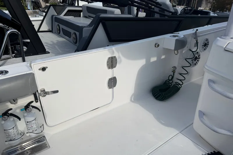 Slide: The Image of 2021 Everglades 335 Center Console boat interior with storage, hose, and fire extinguishers. - 6