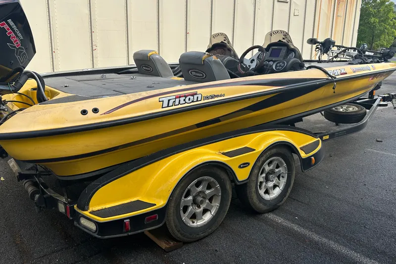 Slide: The Image of Yellow 2006 Triton 21 TrX boat on trailer, featuring dual seats and Mercury Pro XS engine. - 2