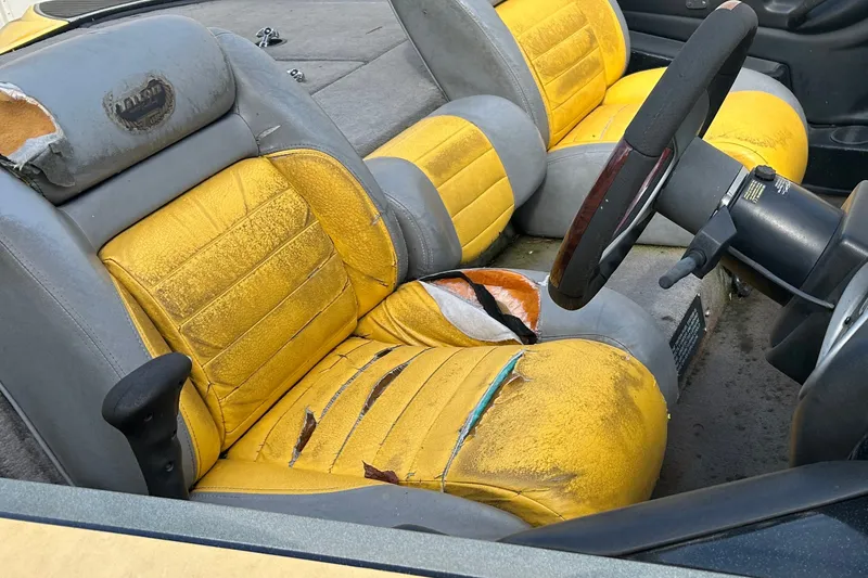 Slide: The Image of Worn interior of a 2006 Triton 21 TrX boat with yellow and gray seats. - 8