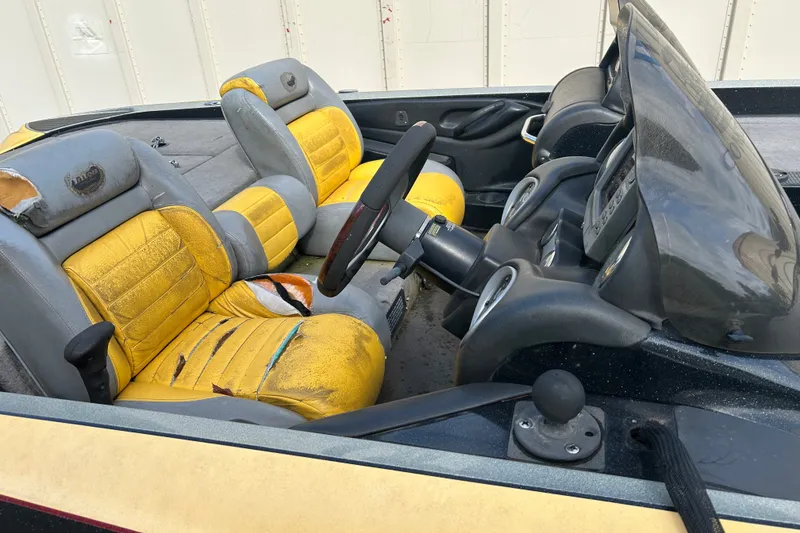 Slide: The Image of 2006 Triton 21 TrX boat interior with worn yellow and gray seats. - 6