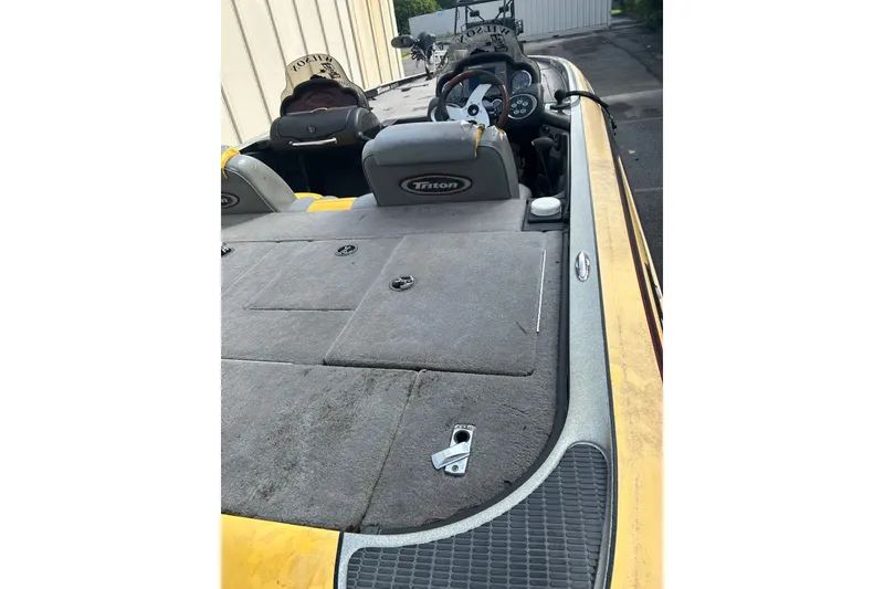 Slide: The Image of 2006 Triton 21 TrX boat interior with gray carpet and steering console. - 4