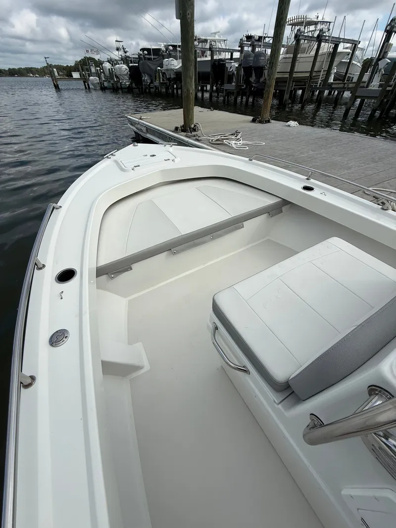 Slide: The Image of The image shows the bow of a 2023 Parker 1801 Center Console boat docked at a pier. - 18