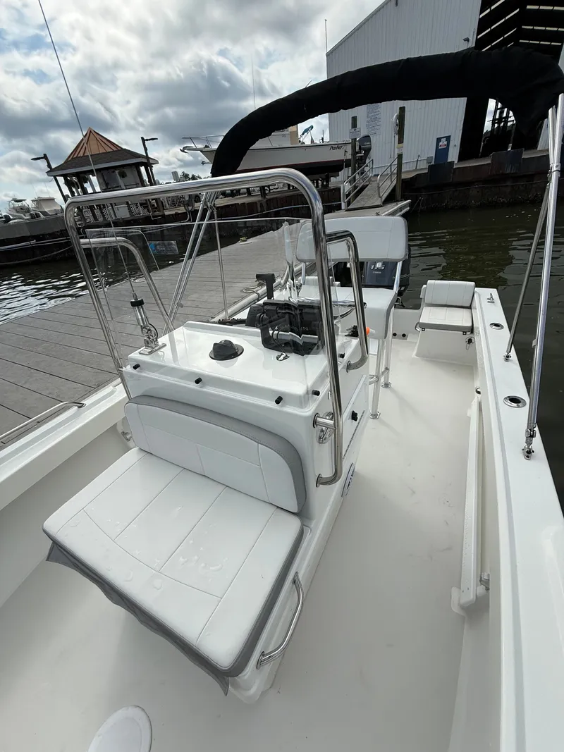 Slide: The Image of A 2023 Parker 1801 Center Console boat at a dock, featuring a white console and seating. - 21