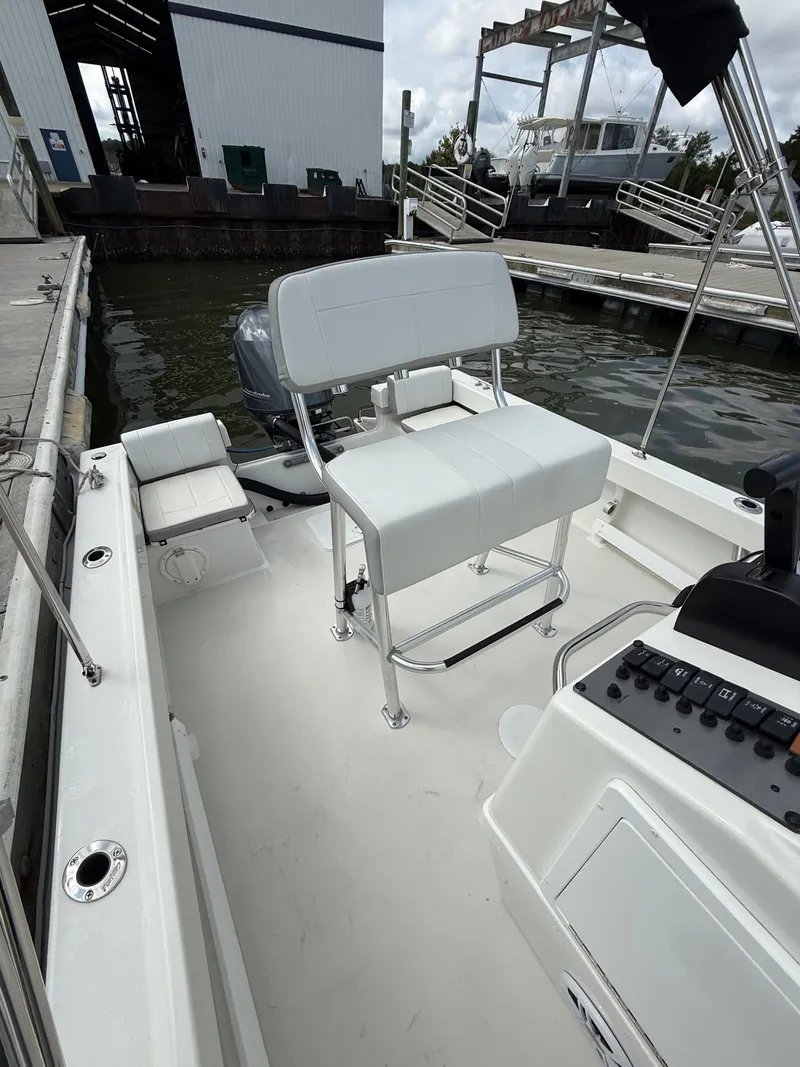 Slide: The Image of The image shows a 2023 Parker 1801 Center Console boat with white seating and a helm console. - 23