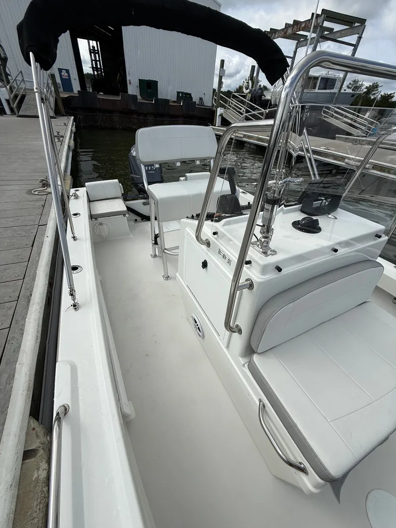 Slide: The Image of A 2023 Parker 1801 Center Console boat docked. It features white upholstery and stainless steel railings. - 22